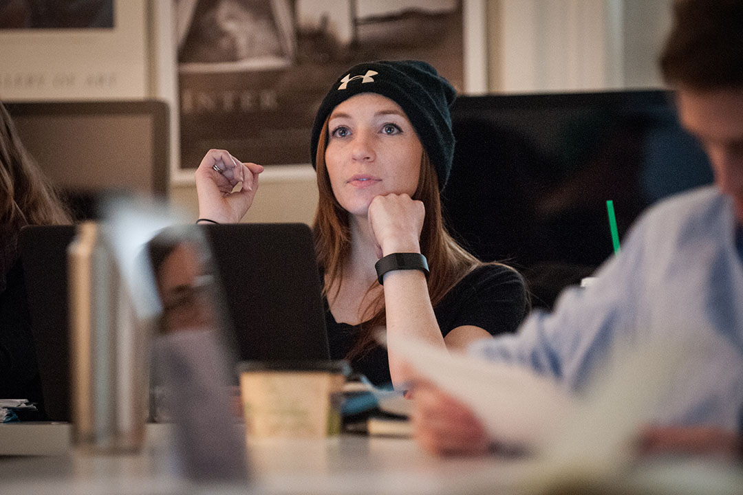 A student in a film classroom with movie posters behind her